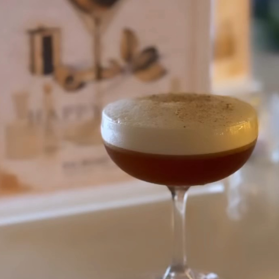 Non alcoholic Cocktail with foam in a glass against a blurred bar background