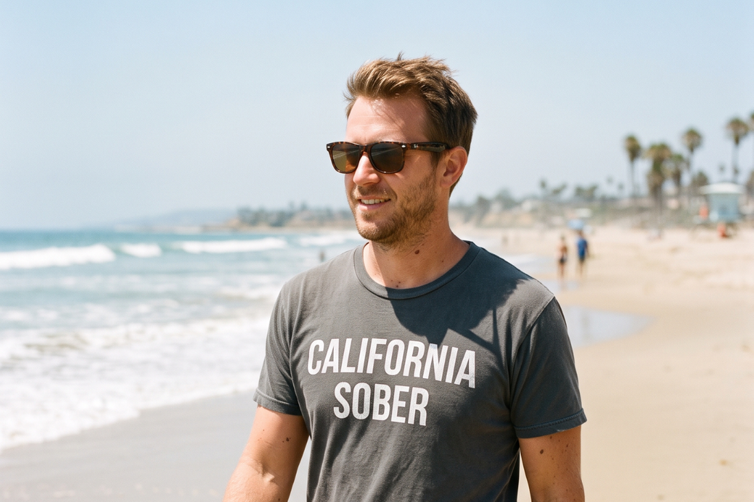 A man walking on a California beach in a California Sober t-shirt