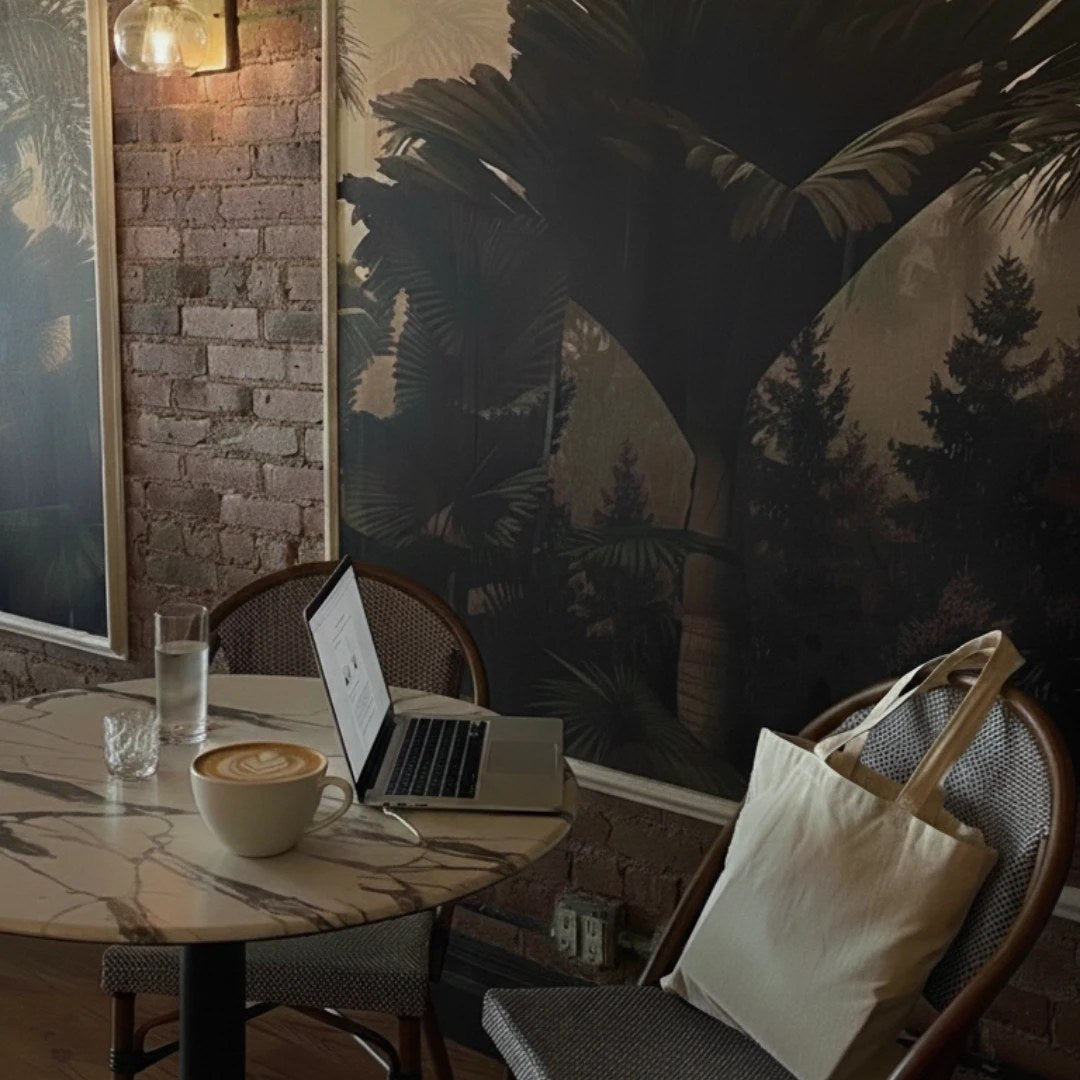 A latte and a laptop at a marble table by the mural