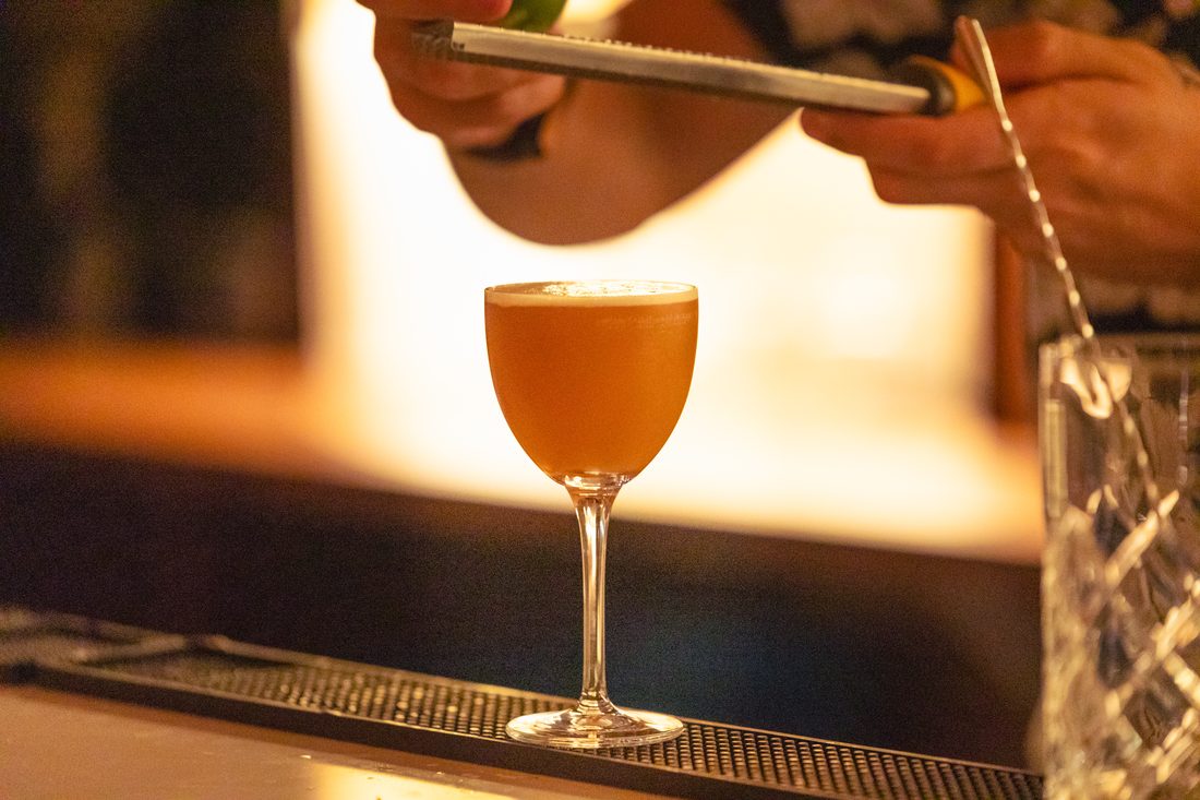A cocktail being finished at the bar
