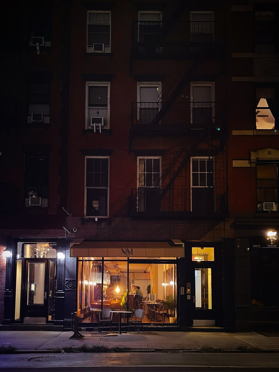 The storefront of No More Cafe at night